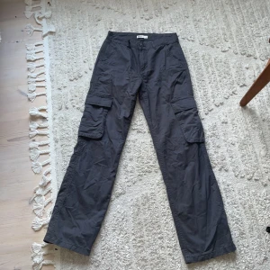 Mörkgråa cargo byxor  - Säljer dessa cargo byxor som kannapt är använda då dom alltid varit lite för små. På sista bilden ser man mycket tydligare vad det är för färg. Det är dom som va väldigt populära i början av förra året från Gina 🫶🏼Dom är dessutom lågmidjade 