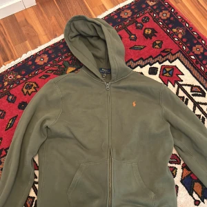 Grön Ralph lauren kofta  - Hej säljer min gröna Ralph lauren kofta eftersom den blivit för liten för mig. Koftan är i jätte bra skick. Perfekt kofta som går med mjukisbyxor och jeans Köpt för nypris 1050. 