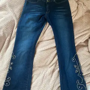 Lågmidjade bootcut jeans med coola detaljer på benen (en ”pärla” borta på höger ben)! 39 cm bredd, 102 cm full längd,  79 cm innerbenslängd. Säljer då de är för stora (jag är 166 cm). Skriv gärna i DM vid frågor 💗