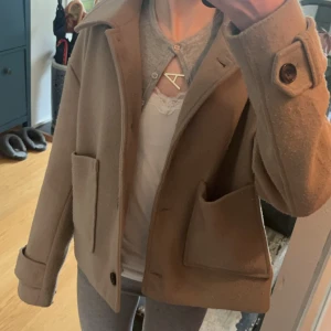 Nelly kort vår/höst kappa beige - Jättefin kort kappa från Nelly som är lite knopprig men inga andra defekter! Super fin nu till våren! Storlek XS💕