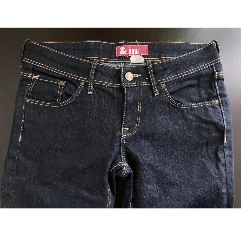 Mörkblå jeans i slim modell med medel/låg midja. Stadig denim med lätt stretch. Finns en dragen tråd på höger knä. Mått i cm: midja 38; höft 43; benvidd nedanför grenen 24; benöppning 15; grenhöjd fram/bak 19/31; innerben 79.. Jeans & Byxor.