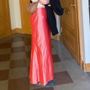 Lång röd kjol - Så snygg lång röd kjol i glansigt material! ❣️knappt använd och i mycket fint skick 