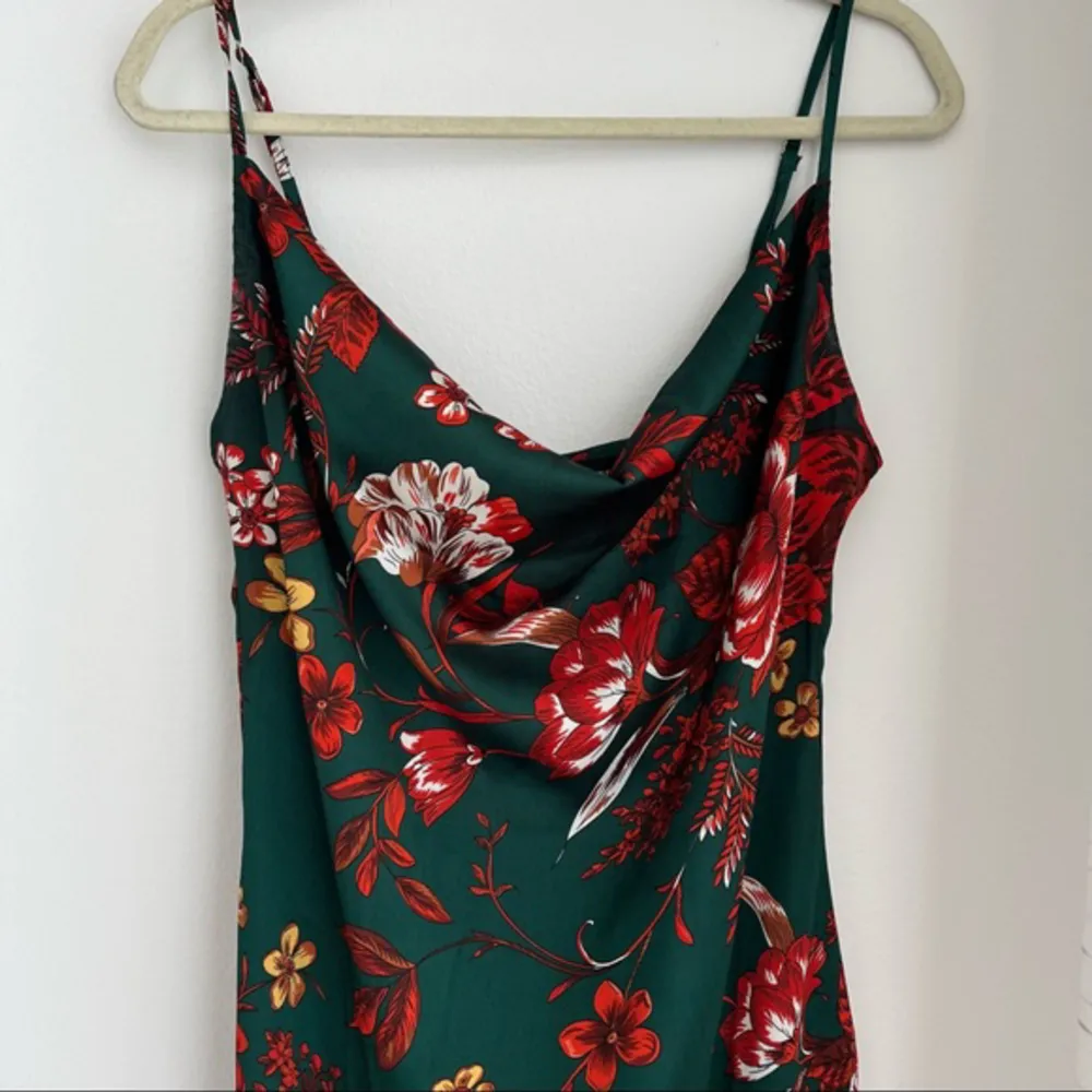 Grön klänning med slits och röda blommor i satin. Köpt för ett bröllop, aldig använt den igen 😢. Klänningar.