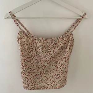 Blommig topp - Supersöt blommig topp/Linné från lindex storlek XS. Materialet är som en bikini/baddräkt.  