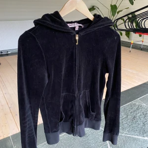 Svart Juicy Couture zip-up - En supersnygg vintage Juicy Couture zip-up tröja i ett mycket bra skick! Tröjan är i strl M men passar S. Den är i velour och har gulddetaljer🤍 dragskedjan funkar utmärkt! Kontakta mig för fler bilder eller liknande💋