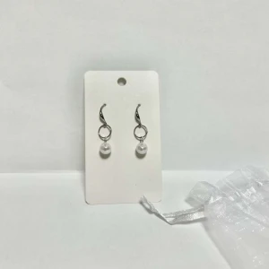 Örhänge med pärla - Nickelfria, handgjorda örhängen tillverkade av Smyck uf.  Silvriga korta med hängande pärla  (Oanvända)