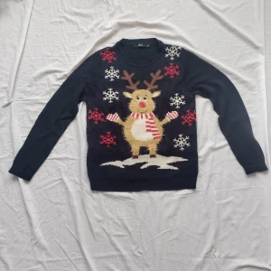 Jultröja med en ren på - En gullig jultröja med en liten ren på. Tröjan är ganska tunt stickad, renen på tröjan är lite fuzzy. Har haft den i några år och har inte använt den jättemycket.