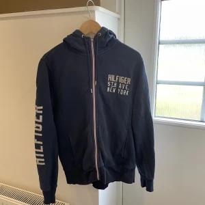 Tommy Hilfiger Zip tröja - Säljer nu min zip tröja då den inte används längre, jag själv har användt den 3 ggr, på andra bilden ser man att den har några små hål men inget man ser när man bär den😊 kan gå ner i pris vid snabb affär 