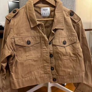 Beige jeansjacka - Jeansjacka i en brun-beige färg.