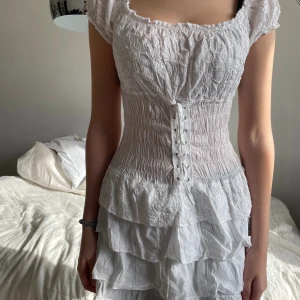 klänning med snörning - är stretchig och har fin passform då man kan spänna åt den som man önskar. Passar en XS/S, stretch.