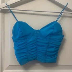 Topp Gina tricot - Topp från Gina tricot i strl XS. Aldrig använd då den inte riktigt passade mig tyvärr❤️ skriv för fler bilder eller vid frågor, pris kan diskuteras❤️lite mer åt det turkosa hållet i färgen