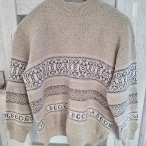 Vintage stickad tröja i ullmix  - Äldre tröja med 33% ull. Längd: 66cm Bredd: 56cm (armhåla till armhåla) Midja: 46cm  Elastisk och töjbar.