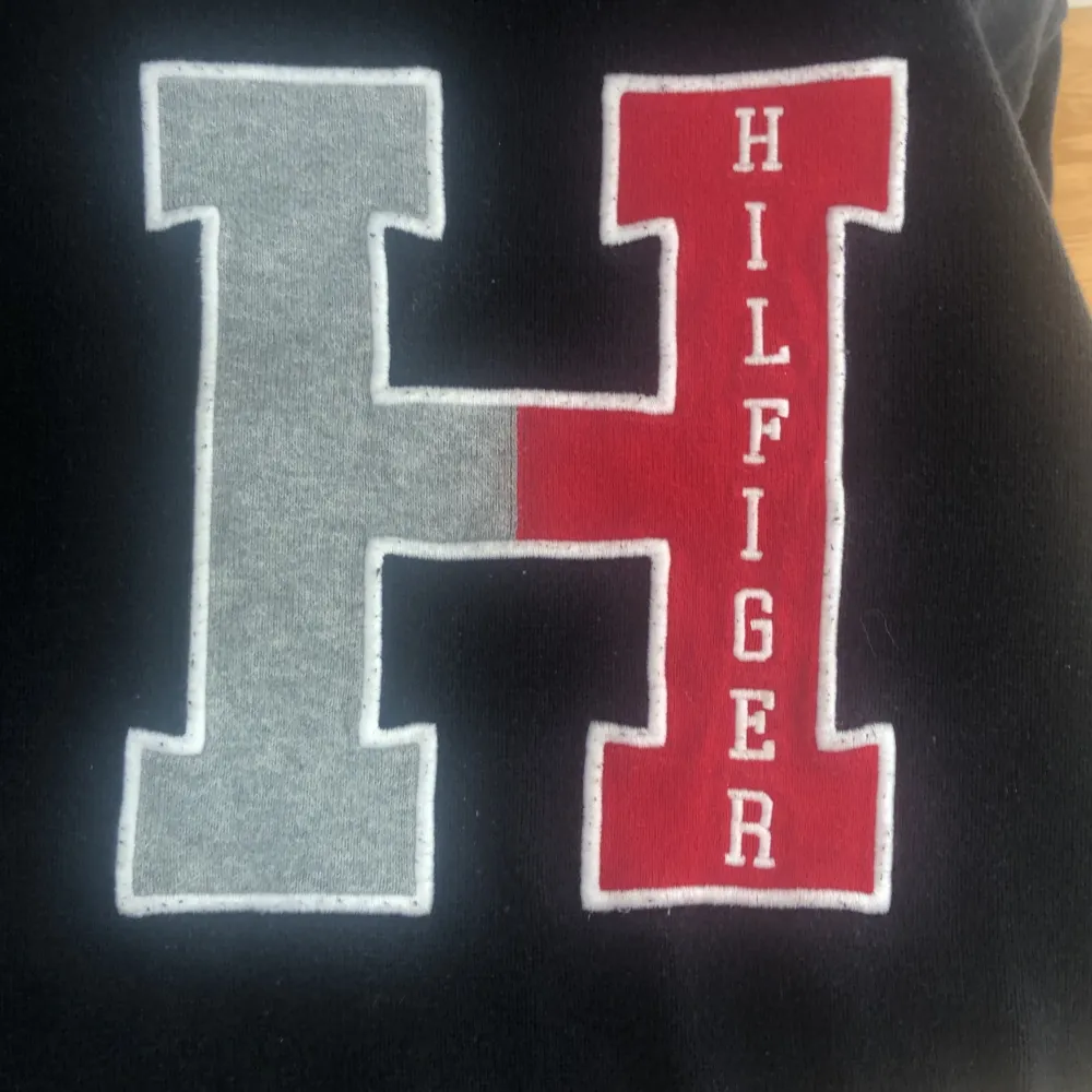 Mörk blå tröja med ett H där det står Hilfiger . Hoodies.