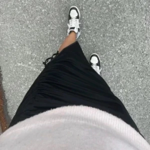 Svart lång midi kjol långkjol snörning slits rosett rysch detaljer stockholmstil stockholmsstil - En svart långkjol med detaljer/slits på sidan.