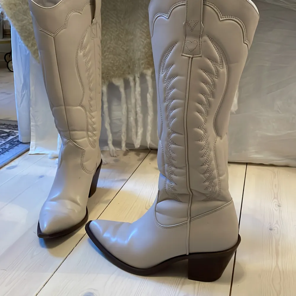 Säjer beige (vitgråa) cowboy boots, med bruna sulor, 6 cm klack men vääldigt bekväma och lätt att gå i. Kan dock upplevas som lite tighta och lite svårt att ta av. Jag har ej använt de så mycket, men perfekta fest skor. . Kengät.