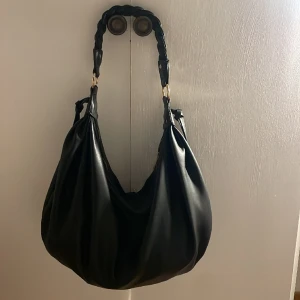 Svart väska  - As snygg väska med flätad axelrem, väskan rymmer förvånansvärt mycket:) fint skick, pris kan diskuteras till viss del💕