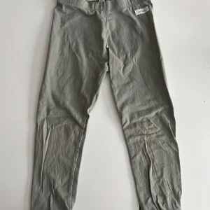 Tajts  - Ett par gröna tajts från Newbie i storlek 110 med spets nertill. Min lillasyster har växt ur dem och nu söker byxorna en ny ägare. 