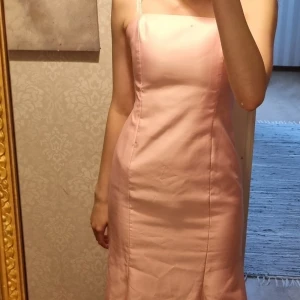 Ljusrosa balklänning  - Ljusrosa balklänning som det inte står någon storlek på men som jag är ganska säker på är i XS. Den är ganska tajt men sätter sig fint på kroppen. Tyvärr lite för kort för mig som är runt 170.  Aldrig använd! 