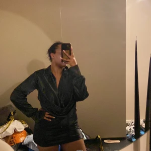 Snygg och smickarnde svart kort klänning! - Denna klänningen är oanvänd med prislapp på. Klänningen är från Nelly och är i strl S. Perfekt klänning till utgång💕