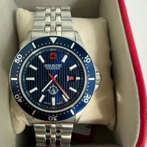 Swiss klocka  -  Säljer en fin Swiss Military Hanowa klocka med blå urtavla och silverfärgat armband. Klockan är i gott skick och har använts 2-3 gånger ! Den är vattentät och har en datumvisning. Kom pm för fler bilder eller frågor kring klockan. ✨✨