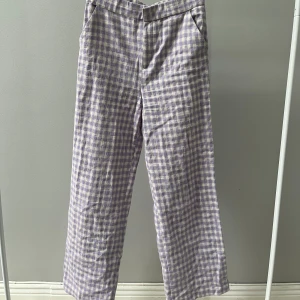 Rutiga byxor Zara - Vit och lila-rutiga byxor från Zara. Bomull och polyester.