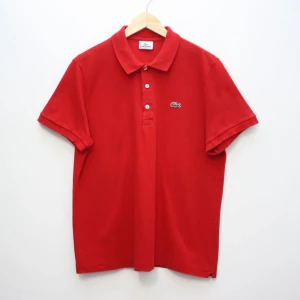 Röd Lacoste polo - En röd Lacoste polo i size 6, bra skick, knappast använd. Bara skicka ifall du har några funderingar!