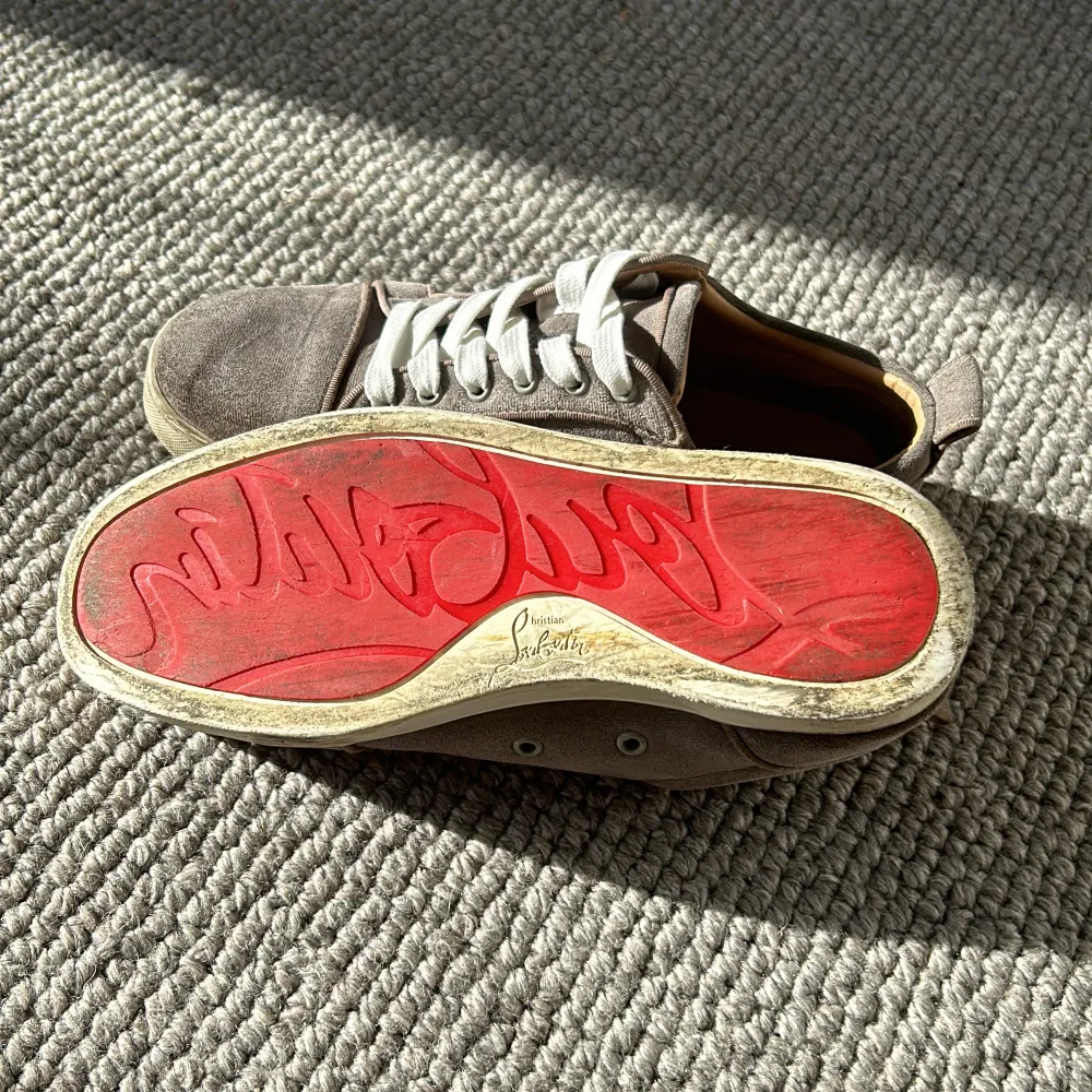 Ett par fina Louboutin skor i färgen grå/beige, Skick: 8/10, har bytt skosnören, boxen,dustbag och orginal  skosnörerna tillkommer. De är i storlek 41 men passar 42 bra. Tar även byten!. Skor.