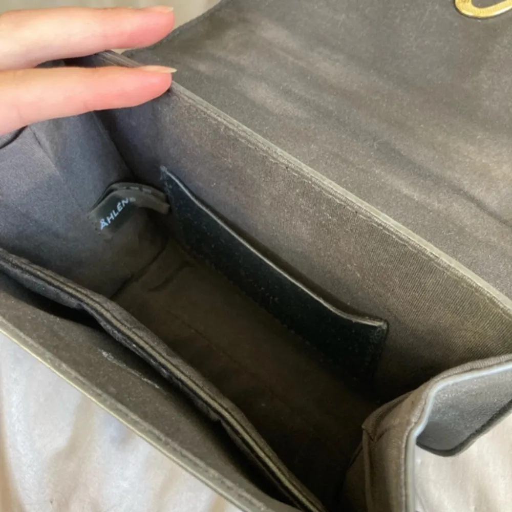 Väska från Åhléns, lite defekter på insidan men syns inte på utsidan 15 cm hög 18,5 bredd . Väskor.