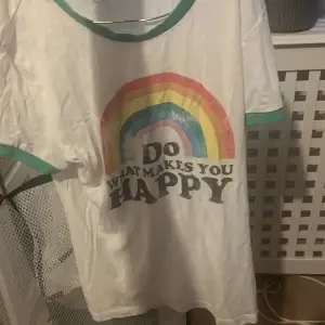 En sliten tröja med en regnbåge på och text där det står do What makes you happy , regnbågen är lite sliten men annars är den lite ut töjd 