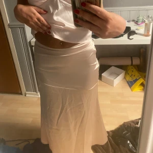 Beige/rosa silkeskjol - Säljer denna jättefina silkeskjolen som tyvärr sitter lite tajt på mig