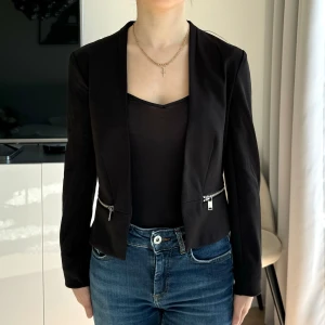 Kort kavaj - Svart kort kavaj strl 34. Divided från H&M. Bra skick. För liten för mig som i vanliga fall bär XS, passar bättre på en XXS.