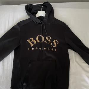 Hugo boss hoodie  - Hej! Säljer en guld Hugo boss hoodie som är använd ett få tall gånger inga skador och den är i bra skick. Storlek XS