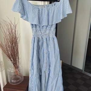 Blårandig midi klänning  - Säljer denna jättefina blårandiga Midi klänning från zara. Sitter väldigt fint eftersom den har resor i midjan. Använd fåtal gånger 