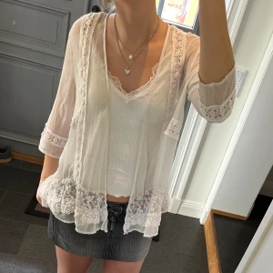 Vit spetsblus - Vit trekvartsärmad blus med spets från Pull&Bear i storlek S. Fint skick förutom en liten slitning långt ner i fram (sista bilden) men det syns inte när man har på sig blusen. Använd gärna köp nu!