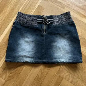 Kort jeanskjol med stretch och kul detaljer. 30 cm lång. 