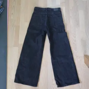 Ett par vida högmidjade jeans från weekdag i färgen vintage black, stl midja:27 längd:30. Snygga jeans som jag tyvärr växt ur. Länk till jeansen: https://www.weekday.com/sv-se/p/women/jeans/ace-high-wide-jeans-vintage-black-025/