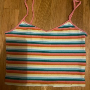 Färgglad crop top - En färgglad randig crop top från monki. Den har en fläck från målarfärg som inte går bort men den syns knappt enligt mig. Annars är den i bra stick och materialet är stretchigt. 💗 