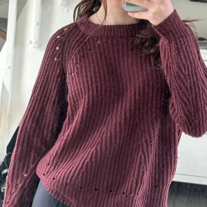 Vinröd stickas tröja  -  Vinröd stickad tröja med hål i (som ska vara där) använd ett fåtal gånger men inga synliga tecken