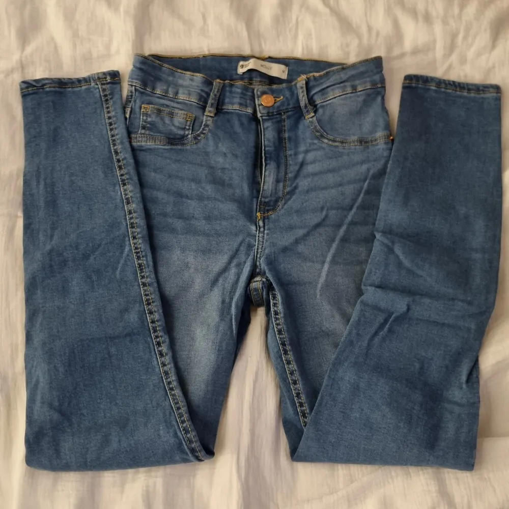 Blåa högmidjade jeans från Gina Tricot. Modell: Molly, strl. M, slim fit. Extremt stretchiga med knapp och dragkedja. . Jeans & Byxor.