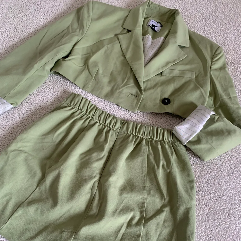 Supersnyggt set från Bershka med croppad kavaj och matchande grön kjol. Har vikt upp ärmarna på kavajen. Använd en gång, i superfint skick men lite skrynklig efter tvätt. . Kostymer.