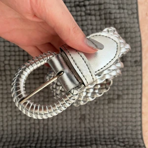 Silvrigt bälte - Silvrigt vintage bälte från 70/80 talet, jättefint skick, aldrig använt! Väldigt reglerbar storlek,  då den är flätad kan man välja exakt vilken storlek som passar. 🩶