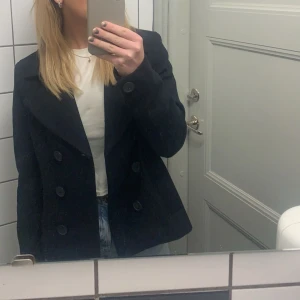 Kort kappa - Kort marinblå kappa som är jättefin nu till våren! Den är av tjockt material. Köpt på secondhand och använt ett fåtal gånger själv. Ser oanvänd ut! Passar mig som har s/xs