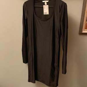 Helt ny svart tajt klänning från hm med prislappen kvar, aldrig använd. Materialet är polyester  Storlek: M