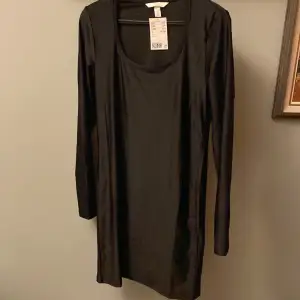 Helt ny svart tajt klänning från hm med prislappen kvar, aldrig använd. Materialet är polyester  Storlek: M