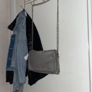 Väska från Tiamo - Säljer nu min gråa Tiamo väska i  storlek M då den knappt kommit till användning. Inga skador eller defekter den är nästan som ny.  Säljer för 300 men kan gå ner i priset vid snabb affär💞