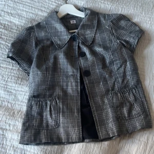 Cool topp - Jätte cool kortärmad blus med fickor och knappar. Super söt med lite silver i tyget.  
