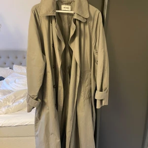 Grön trench  - Militärgrön lång trenchcoat från Weekday i en oversized XS, men passar både S och M beroende på hur oversized man vill ha den. Inga skador eller defekter. Nypris 1200kr, mitt pris 590kr, men kan diskuteras❤️