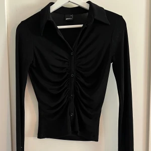 Svart topp från Gina Tricot - Toppen är liten i storlek så skulle säga att den passar xxs-s beroende på hur stor byst man har. Den är använd få gånger!