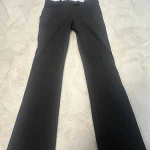 Lågmidjade svarta kostymbyxor - Säljer ett par nya Lågmidjade svarta kostymbyxor från märket GAP. De faller väldigt fint på benen! Storleken på ettiketten år eu 32, men de är också som 34. Midjemåttet är 38 och innerbenslängden är 83. ifall man vill sprätta upp finns 5cm + 💕