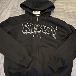 Risky zip hoodie - Svart Risky zip hoodie i storlek XS Ny pris 1000kr  Aldrig använd, säljer på grund av att den är för stor.